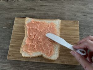 明太子バターをパンに塗る